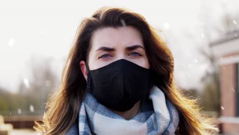 Mujer-Con-Mascarilla-Protectora-Reutilizable-En-Invierno.-Concepto-De-Salud,-Seguridad-Y-Pandemia:-Mujer-Joven-Con-Mascarilla-Protectora-Reutilizable-De-Color-Negro-Al-Aire-Libre-Sobre-La-Nieve-En-Invierno