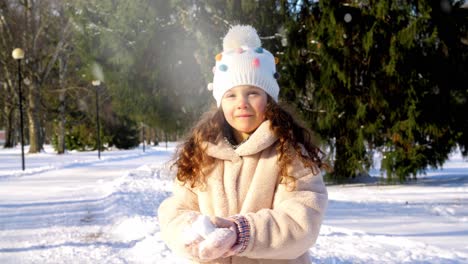 Niña-Feliz-Tirando-Nieve-En-El-Parque-De-Invierno.-Concepto-De-Infancia,-Ocio-Y-Temporada:-Niña-Feliz-Tirando-Nieve-En-El-Parque-De-Invierno