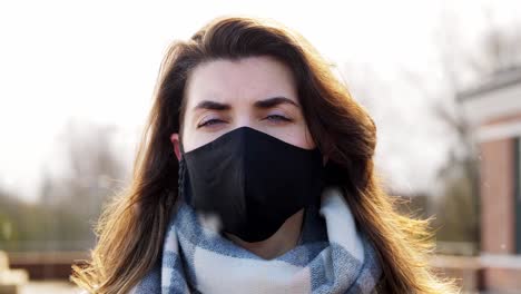 Mujer-Con-Mascarilla-Protectora-Reutilizable-En-Invierno.-Concepto-De-Salud,-Seguridad-Y-Pandemia:-Mujer-Joven-Con-Mascarilla-Protectora-Reutilizable-De-Color-Negro-Al-Aire-Libre-Sobre-La-Nieve-En-Invierno