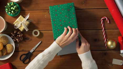 Woman-showing-Christmas-gift-wrapped-in-craft-paper-with-red-bow.-Vertical-video.Woman-showing-Christmas-gift-wrapped-in-craft-paper-with-red-bow.-Smiling-female-is-holding-New-Year-present-box.-Celebrating-Merry-Christmas-or-Happy-New-Year-2025.-Vertical-video