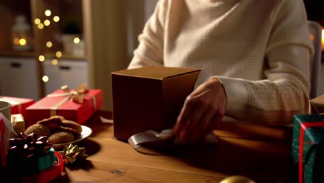 Happy-Woman-in-Santa-Hat-Opens-Christmas-Gift-on-White.Happy-woman-in-Santa-hat-opens-Christmas-gift-discovering-phone-on-white-background.-Lady-screams-expressing-joy-with-expensive-present-slow-motion