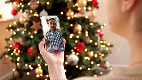 Mujer-Con-Teléfono-Inteligente-Tiene-Una-Videollamada-En-Navidad.-Concepto-De-Navidad,-Tecnología-Y-Vacaciones:-Primer-Plano-De-Una-Mujer-Joven-Con-Un-Teléfono-Inteligente-Que-Tiene-Una-Videollamada-Con-Su-Madre-Mayor-En-Casa