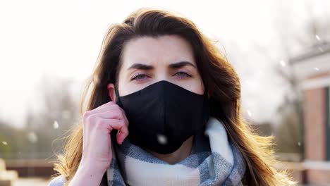 Mujer-Con-Mascarilla-Protectora-Reutilizable-En-Invierno.-Concepto-De-Salud,-Seguridad-Y-Pandemia:-Mujer-Joven-Con-Mascarilla-Protectora-Reutilizable-De-Color-Negro-Al-Aire-Libre-Sobre-La-Nieve-En-Invierno