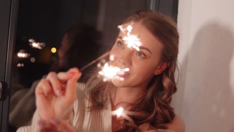 Happy-Young-Woman-Dancing-with-Sparklers.Happy-young-woman-dancing-with-sparklers-near-snowy-pine-trees