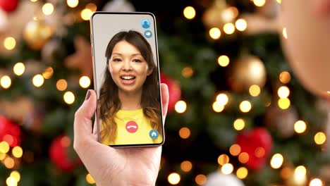 Mujer-Con-Teléfono-Inteligente-Tiene-Una-Videollamada-En-Navidad.-Concepto-De-Navidad,-Tecnología-Y-Vacaciones:-Primer-Plano-De-Una-Mujer-Joven-Con-Un-Teléfono-Inteligente-Que-Tiene-Una-Videollamada-Con-Su-Madre-Mayor-En-Casa