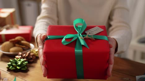 Eine-Frau-Dekoriert-Eine-Weihnachtsgeschenkschachtel,-Während-Sie-Auf-Der-Couch-Sitzt.-Frauenhände-Packen-Ein-Neujahrsgeschenk.-Eine-Frau-Dekoriert-Eine-Weihnachtsgeschenkschachtel,-Während-Sie-Auf-Der-Couch-Sitzt.