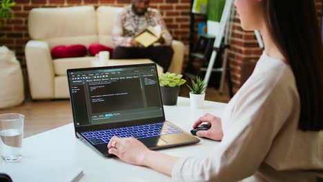 Asian-female-programmer-works-on-coding-software-in-a-home-office-setup