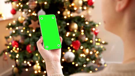 Woman-Holding-Smartphone-with-Green-Screen-for-Mockup.A-woman-holding-a-smartphone-with-a-green-screen-for-mockup-purposes,-with-a-focus-on-the-phone