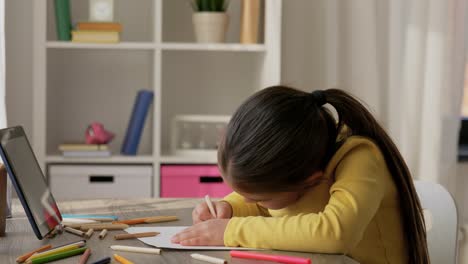 Una-Niña-Feliz-Dibujando-Y-Coloreando-Con-Un-Lápiz-Azul-En-Su-Escritorio.Una-Niña-Feliz-Dibujando-Y-Coloreando-Con-Un-Lápiz-Azul-En-Su-Escritorio.