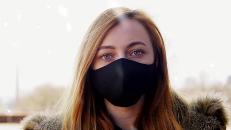 Woman-Wearing-Reusable-Protective-Mask-in-Winter.health,-safety-and-pandemic-concept-–-young-woman-wearing-black-face-protective-reusable-barrier-mask-outdoors-over-snow-in-winter