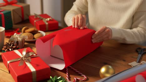 Woman-showing-Christmas-gift-wrapped-in-craft-paper-with-red-bow.-Vertical-video.Woman-showing-Christmas-gift-wrapped-in-craft-paper-with-red-bow.-Smiling-female-is-holding-New-Year-present-box.-Celebrating-Merry-Christmas-or-Happy-New-Year-2025.-Vertical-video