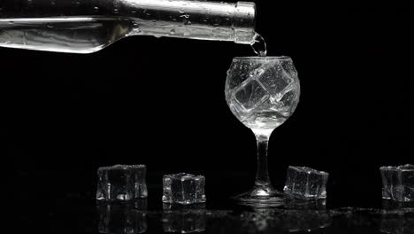 Pouring-up-shot-of-vodka-into-glass.-Black-background.-Pour-of-alcohol-drink