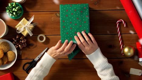 Woman-showing-Christmas-gift-wrapped-in-craft-paper-with-red-bow.-Vertical-video.Woman-showing-Christmas-gift-wrapped-in-craft-paper-with-red-bow.-Smiling-female-is-holding-New-Year-present-box.-Celebrating-Merry-Christmas-or-Happy-New-Year-2025.-Vertical-video