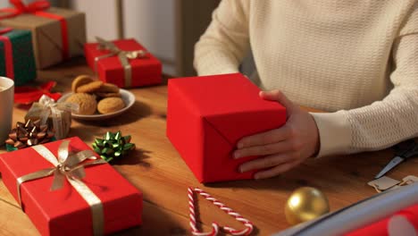 Woman-showing-Christmas-gift-wrapped-in-craft-paper-with-red-bow.-Vertical-video.Woman-showing-Christmas-gift-wrapped-in-craft-paper-with-red-bow.-Smiling-female-is-holding-New-Year-present-box.-Celebrating-Merry-Christmas-or-Happy-New-Year-2025.-Vertical-video