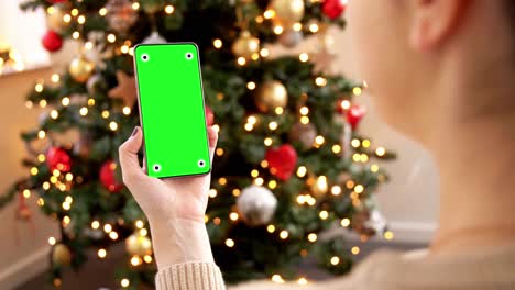 Woman-Holding-Smartphone-with-Green-Screen-for-Mockup.A-woman-holding-a-smartphone-with-a-green-screen-for-mockup-purposes,-with-a-focus-on-the-phone