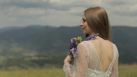 Schöne-Braut-Im-Hochzeitskleid-Aufenthalt-Auf-Den-Bergen-Mit-Blumenstrauß