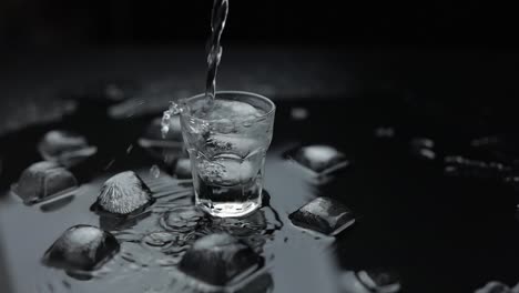 Pouring-up-shot-of-vodka-into-glass.-Black-background.-Pour-of-alcohol-drink