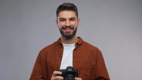 Male-Photographer-Taking-Studio-Portraits-on-Digital-Camera.Back-view-arc-shot-of-professional-male-photographer-taking-studio-portrait-photo-samples-on-dslr-camera-and-looking-at-pictures-on-computer-monitor-while-working-with-assistant-indoors