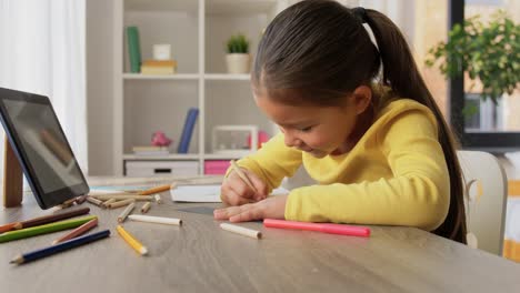 Ein-Glückliches-Kleines-Mädchen,-Das-An-Ihrem-Schreibtisch-Mit-Einem-Blauen-Stift-Zeichnet-Und-Malt.-Ein-Glückliches-Kleines-Mädchen,-Das-An-Ihrem-Schreibtisch-Mit-Einem-Blauen-Stift-Zeichnet-Und-Malt.