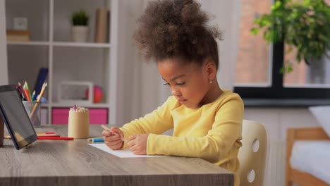 Una-Niña-Feliz-Dibujando-Y-Coloreando-Con-Un-Lápiz-Azul-En-Su-Escritorio.Una-Niña-Feliz-Dibujando-Y-Coloreando-Con-Un-Lápiz-Azul-En-Su-Escritorio.