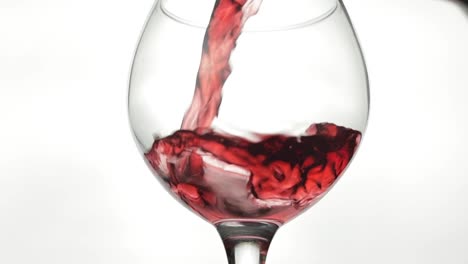 Rose-wine.-Red-wine-pour-in-wine-glass-over-white-background.-Slow-motion