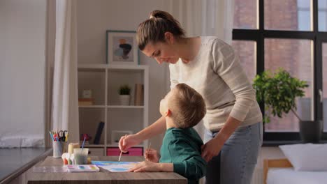 Asian-Mother-and-little-son-drawing-and-coloring-with-Crayons.Asian-Mother-and-little-son-drawing-and-coloring-with-Crayons.-Woman-and-little-child-boy-enjoy-painting-with-Crayons-on-paper-together.