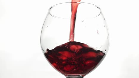 Rose-wine.-Red-wine-pour-in-wine-glass-over-white-background.-Slow-motion