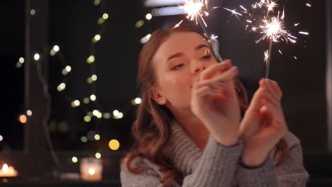 Happy-Young-Woman-Dancing-with-Sparklers.Happy-young-woman-dancing-with-sparklers-near-snowy-pine-trees