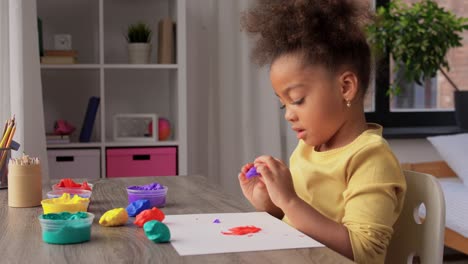 Little-Girl-with-Modeling-Clay-Playing-at-Home.childhood,-creativity-and-hobby-concept-–-little-african-american-girl-with-modeling-clay-playing-at-home