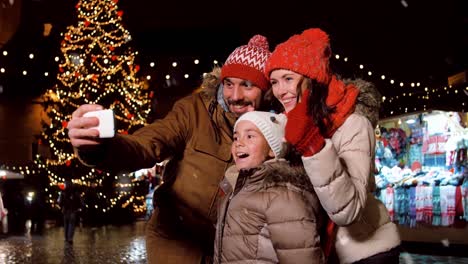 Familia-Joven-Y-Feliz-Tomándose-Selfies-En-Navidad.-Familia-Joven-Y-Feliz-De-Cuatro-Personas-Tomándose-Selfies-En-Navidad,-Cámara-Lenta.-Concepto-De-Celebración-De-Vacaciones-De-Invierno-Y-Año-Nuevo