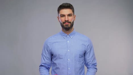 Happy-Young-Man-with-Bunch-of-Flowers-and-Gift-Box.valentines-day,-greeting-and-holidays-concept-–-video-portrait-of-happy-smiling-young-man-with-bunch-of-flowers-and-gift-box-in-shape-of-heart-over-grey-background