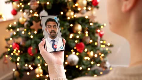 Woman-with-Smartphone-Has-Video-Call-on-Christmas.christmas,-technology-and-holidays-concept-–-close-up-of-young-woman-with-smartphone-having-video-with-senior-mother-call-at-home