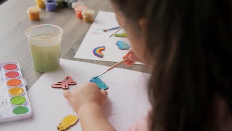 Mother-and-Daughter-Collaborating-on-a-Colorful-Painting-at-Home.Overhead-view-of-a-mother-and-her-young-daughter-working-together-on-a-vibrant-painting,-creating-a-shared-artistic-experience.