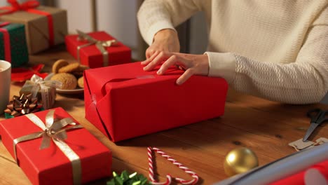 Woman-showing-Christmas-gift-wrapped-in-craft-paper-with-red-bow.-Vertical-video.Woman-showing-Christmas-gift-wrapped-in-craft-paper-with-red-bow.-Smiling-female-is-holding-New-Year-present-box.-Celebrating-Merry-Christmas-or-Happy-New-Year-2025.-Vertical-video