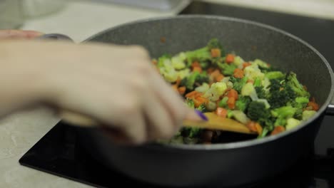 Mixing-fresh-vegetables-on-frying-pan.-Boiling-carrots,-cauliflower,-broccoli