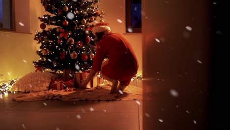 Woman-Placing-Gifts-under-Christmas-Tree.Woman-placing-gifts-under-Christmas-tree-in-front-of-fireplace-in-atmospheric-lights-and-burning-candles.-Christmas-giving-concept.-4k