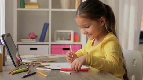 Una-Niña-Feliz-Dibujando-Y-Coloreando-Con-Un-Lápiz-Azul-En-Su-Escritorio.Una-Niña-Feliz-Dibujando-Y-Coloreando-Con-Un-Lápiz-Azul-En-Su-Escritorio.