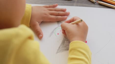 Una-Niña-Feliz-Dibujando-Y-Coloreando-Con-Un-Lápiz-Azul-En-Su-Escritorio.Una-Niña-Feliz-Dibujando-Y-Coloreando-Con-Un-Lápiz-Azul-En-Su-Escritorio.