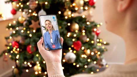 Mujer-Con-Teléfono-Inteligente-Tiene-Una-Videollamada-En-Navidad.-Concepto-De-Navidad,-Tecnología-Y-Vacaciones:-Primer-Plano-De-Una-Mujer-Joven-Con-Un-Teléfono-Inteligente-Que-Tiene-Una-Videollamada-Con-Su-Madre-Mayor-En-Casa