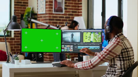 Männlicher-Videoeditor-Arbeitet-An-Einem-Filmprojekt-In-Kreativsoftware-Neben-Chroma-Key