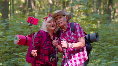 Senior-grandmother-grandfather-blogger-tourists-taking-selfie-photo-portrait-on-smartphone-in-forest