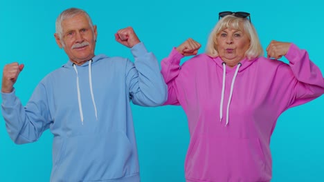 Senior-man-woman-grandparents-showing-biceps-feeling-power-strength-to-fight-for-rights,-success-win