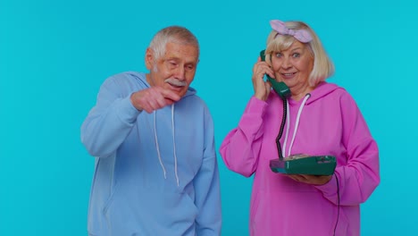 Senior-grandparents-pensioners-talking-on-wired-vintage-telephone-of-80s,-says-hey-you-call-us-back