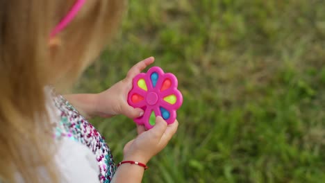 Nahaufnahme-Eines-Mädchens,-Das-Im-Park-Mit-Einem-Sensorischen-Anti-Stress-Spielzeug-Spielt-Und-Sich-Dreht,-Stress--Und-Angstlinderung