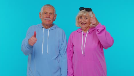 Senior-stylish-grandparents-pensioners-looking-approvingly-at-camera-showing-thumbs-up,-like-sign