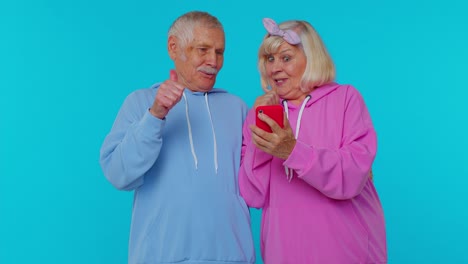 Happy-senior-couple-man-woman-grandparents-use-mobile-phone-celebrating-found-out-great-big-win-news