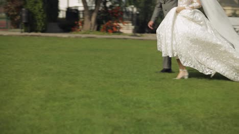 Lovely-newlyweds-caucasian-bride-groom-running-in-park,-holding-hands,-wedding-couple-family