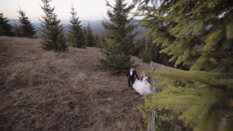 Newlyweds.-Caucasian-groom-with-bride-walking-on-mountain-slope.-Wedding-couple