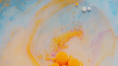 Ink-bubbles-mixed-with-liquid-substance-of-oil,-milk,-soap,-bright-acrylic-paint-on-colorful-surface