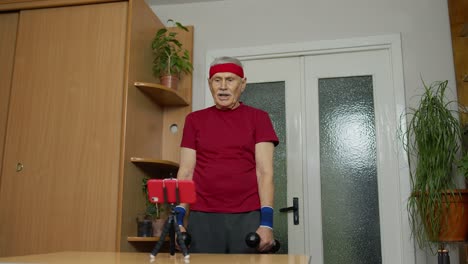 Old-senior-grandfather-man-doing-workout-with-dumbbells,-training,-fitness,-sport-activity-at-home